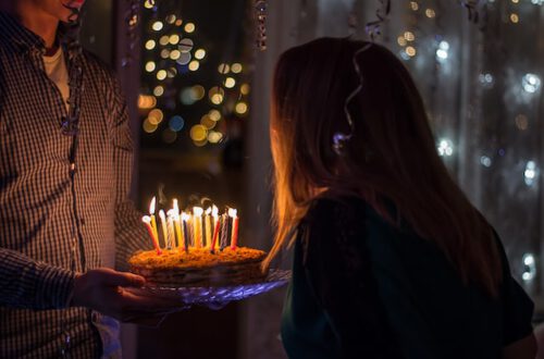 Dziewczyna zdmuchuje świeczki z tortu urodzinowego