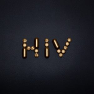 Napis HIV ułożony ze złotych tabletek