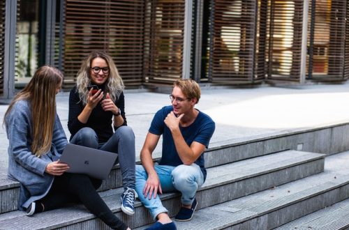 studenci siedzą na schodach