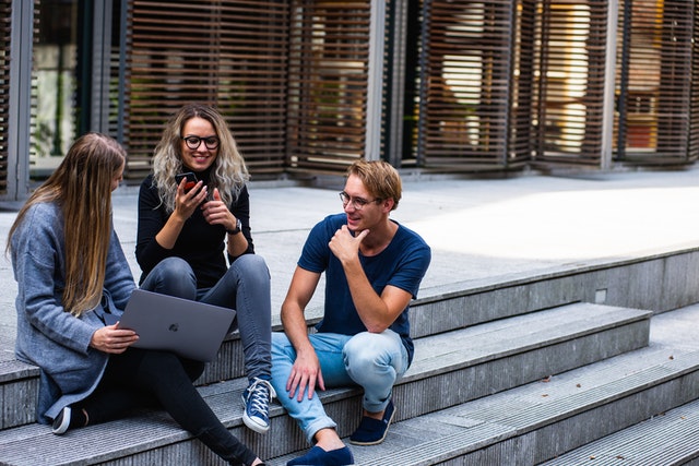 studenci siedzą na schodach